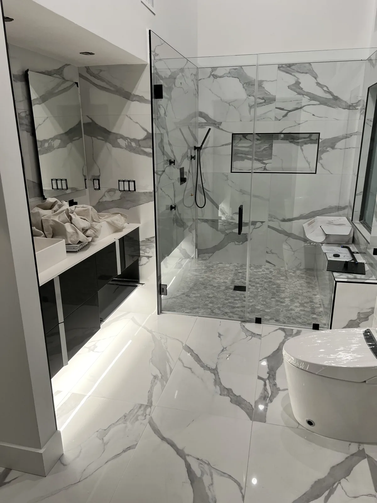 Marble flooring, glass shower enclosure, and dual vanity.