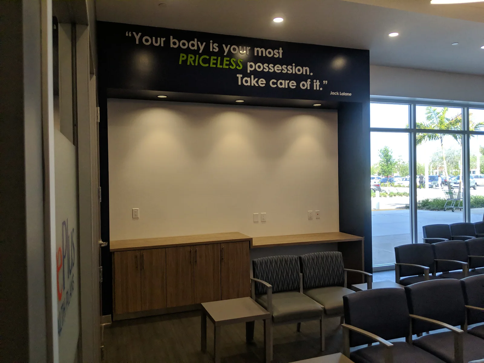 Fitness facility lounge with motivational quote wall and wooden cabinetry.