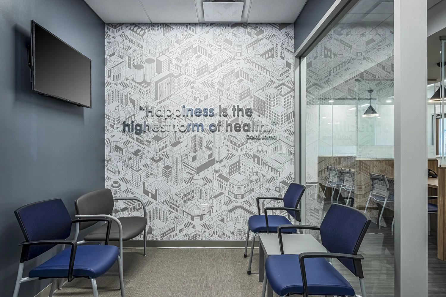Medical office waiting area with blue chairs and isometric city wallpaper.